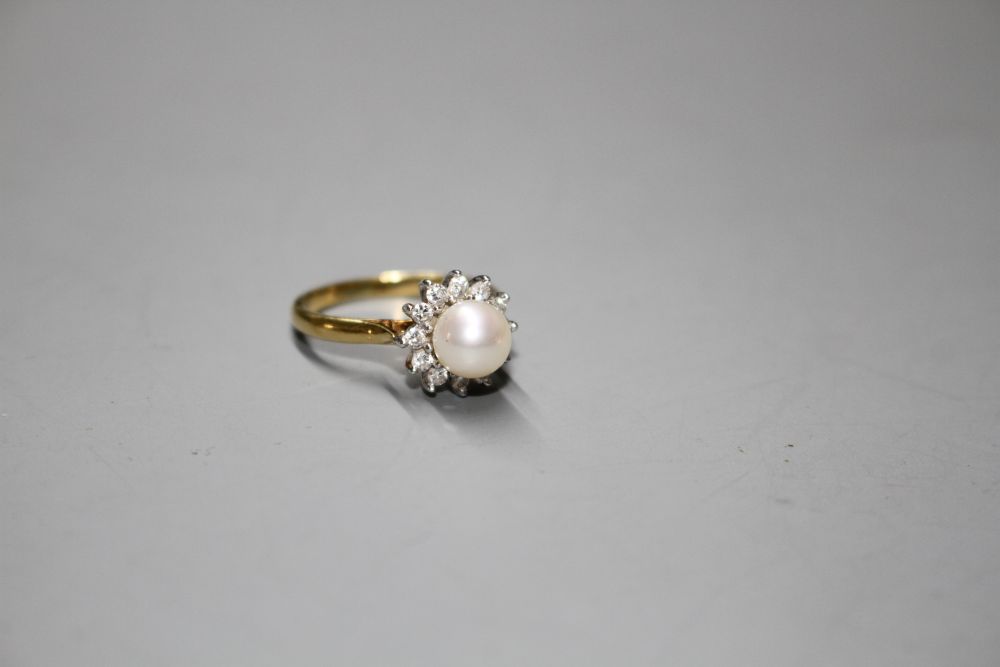 A modern 18ct gold, cultured pearl and diamond cluster set flower head ring, gross 4.4. grams.